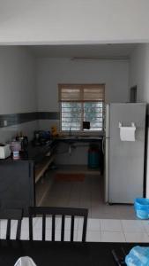 a kitchen with a refrigerator and a window at Affordable Stay @ Rue’s Villa Tropika Apartment, UKM Bangi in Bangi