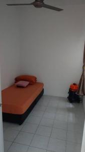 a bed sitting in a room with a white floor at Affordable Stay @ Rue’s Villa Tropika Apartment, UKM Bangi in Bangi