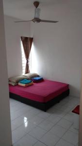 a bed sitting in a room with a window at Affordable Stay @ Rue’s Villa Tropika Apartment, UKM Bangi in Bangi