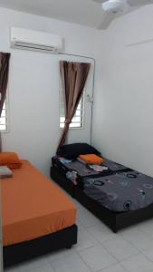 a bedroom with two beds and a heater and windows at Affordable Stay @ Rue’s Villa Tropika Apartment, UKM Bangi in Bangi