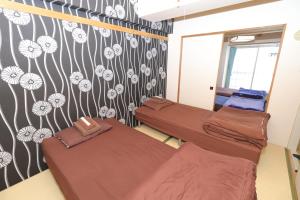 two beds in a room with flowers on the wall at 札幌市中心部大通公園まで徒歩十分観光移動に便利なロケーションh202 in Sapporo