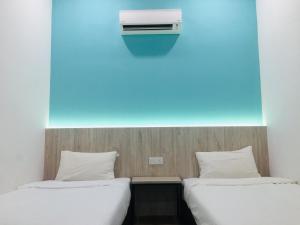 two beds in a room with a air conditioner on the wall at THE WOOD BOUTIQUE HOTEL in Muar +33 photos