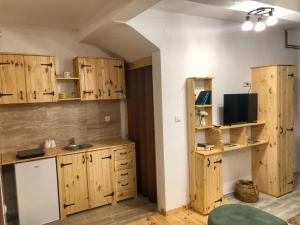 a kitchen with wooden cabinets and a sink at Apartment Winter Star in Kolašin