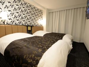Letto o letti in una camera di APA Hotel Toyohashi-Ekimae