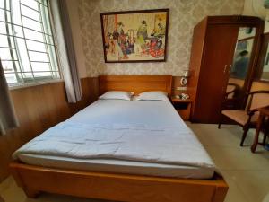 a bedroom with a large bed in a room at Cát tường 2 hotel in Ho Chi Minh City +6 photos
