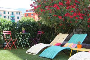 eine Gruppe von Stühlen und Tischen in einem Garten mit Blumen in der Unterkunft Oasi Hotel in Levanto
