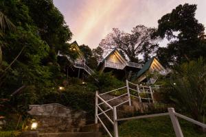 una casa en una colina con un arco iris en el fondo en Orchid Villa Kandy, en Kandy