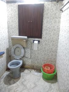 a bathroom with a toilet and a cabinet and buckets at Peaceful Living in Kolkata