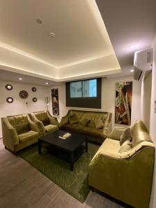 a living room with couches and a table at Desert Rose in Hail