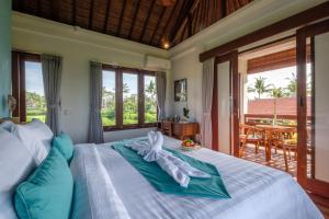 een slaapkamer met een bed met een handdoek erop bij A home, like a dream in Ubud +75 foto's