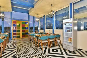 un restaurant avec des tables, des chaises et un réfrigérateur dans l'établissement Hotel Infa - 400m From Golden Temple, à Amritsar