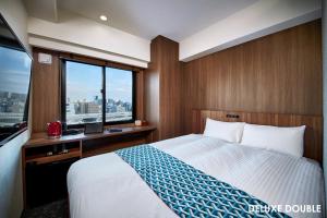 Tempat tidur dalam kamar di HOTEL AMANEK Asakusa Ekimae