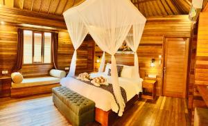 a bedroom with a bed with a canopy at The Akah Cottage - CHSE Certified in Nusa Lembongan
