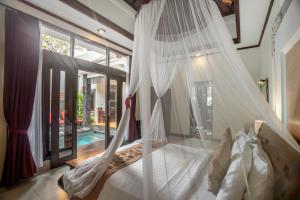 a bedroom with a bed with a mosquito net at The Bali Dream Villa Seminyak in Seminyak