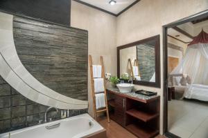 La salle de bains est pourvue d'une baignoire, d'un lavabo et d'un miroir. dans l'établissement The Bali Dream Villa Seminyak, à Seminyak