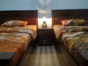 a bedroom with two beds and a lamp on a table at KOPIKUIN bromo homestay in Probolinggo