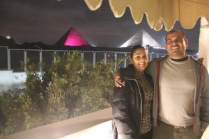 a man and a woman standing in front of the pyramids at Farida Pyramids Boutique Hotel in Cairo
