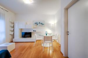 een witte woonkamer met een tafel en stoelen bij The Perfect Place in Rijeka