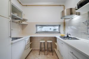 een keuken met witte werkbladen, een wastafel en een raam bij The Perfect Place in Rijeka
