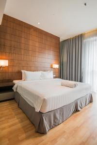 a large bed in a bedroom with a wooden wall at D'Majestic Place by Widebed in Kuala Lumpur