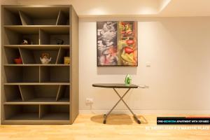 a living room with a table and a bookcase at D'Majestic Place by Widebed in Kuala Lumpur