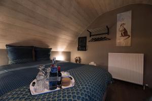 een slaapkamer met een bed en een dienblad met drankjes erop bij B&B De Oude Berg in Mol