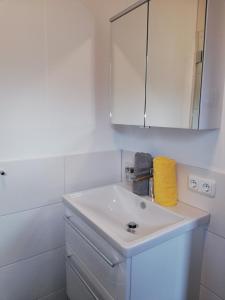 a white bathroom with a sink and a mirror at Ferienwohnung Anton Künzler in Riezlern