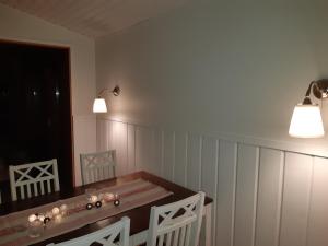 a dining room with a wooden table and two lights at Mäntyniemi in Petäjävesi