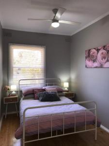 um quarto com uma cama e uma ventoinha de tecto em Cute and Cosy II - Events, Workers, Getaways. em Murray Bridge