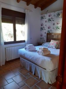 une chambre avec un lit avec des serviettes dessus dans l'établissement Casa rural Quinta de los Almiares, à Candeleda