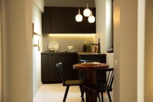 Una cocina con una mesa y sillas en una cocina. en Zen Apartment - Calea Victoriei, en Bucarest 25 fotos más