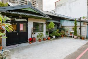 a house with potted plants outside of it at Hearty Cottage in Hualien City