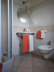 bagno con asciugamani arancioni e bianchi e lavandino di Il Faggio 17 B&B ad Artena