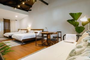 1 dormitorio con 2 camas y mesa en Hearty Cottage en Hualien