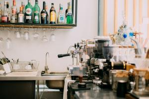 un bancone della cucina con macchinetta del caffè e bottiglie di alcol di Dali Blocks · Cafe & Travel Hotel a Dali