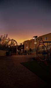 um parque infantil num parque com um pôr-do-sol ao fundo em Seven Garden Alhada Suites em Al Hada