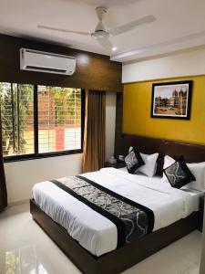 sypialnia z dużym łóżkiem i oknem w obiekcie Hotel Crystal Luxury Inn- Bandra w Bombaju