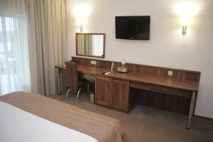 a hotel room with a bed and a television at Porto Riva in Zaporozhye