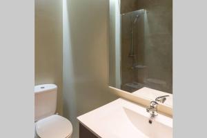 Un baño con inodoro, lavabo y ducha. en Suite Alero, en Mairena del Aljarafe