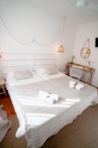 a bedroom with a large white bed with towels on it at Hostal Sa Posada Set Cales in Ciutadella