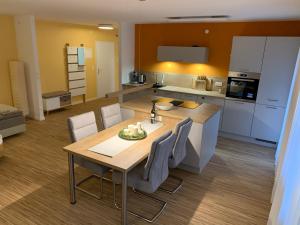 eine Küche mit einem Holztisch und eine Küche mit weißen Geräten in der Unterkunft Moderne Ferienwohnung nahe SWR und Golfplatz in Baden-Baden