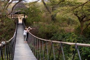 a man and woman standing on a bridge at Ololo Safari Lodge in Nairobi