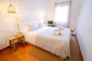 休达德亚Hostal Sa Posada Set Cales的卧室里有一张白色的大床，床上放着毛巾