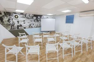 a room with white chairs and a whiteboard at "Bakfar" Kfar Szold Country Lodging in Kefar Szold