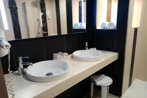 a bathroom with two white sinks and a mirror at Best Western Hôtel Royan Océan in Royan