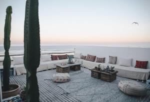 a living room with white couches and cactus at Blue Waves Surf House in Agadir