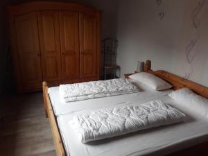 two beds with white sheets and pillows in a bedroom at Apartment Ahoi in Büsum