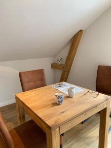 a wooden table with two chairs at FeWo Herrmann in Petersdorf auf Fehmarn