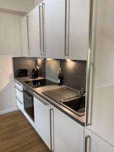 a kitchen with white cabinets and a sink at FeWo Herrmann in Petersdorf auf Fehmarn