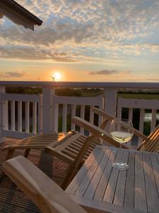 einen Tisch und Stühle auf einer Terrasse mit Sonnenuntergang in der Unterkunft FeWo Herrmann in Petersdorf auf Fehmarn